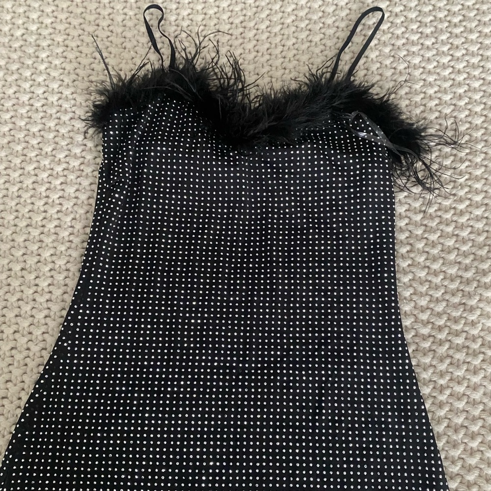 Black shiny sparkly and has feathers skin tight dress, really cute for parties